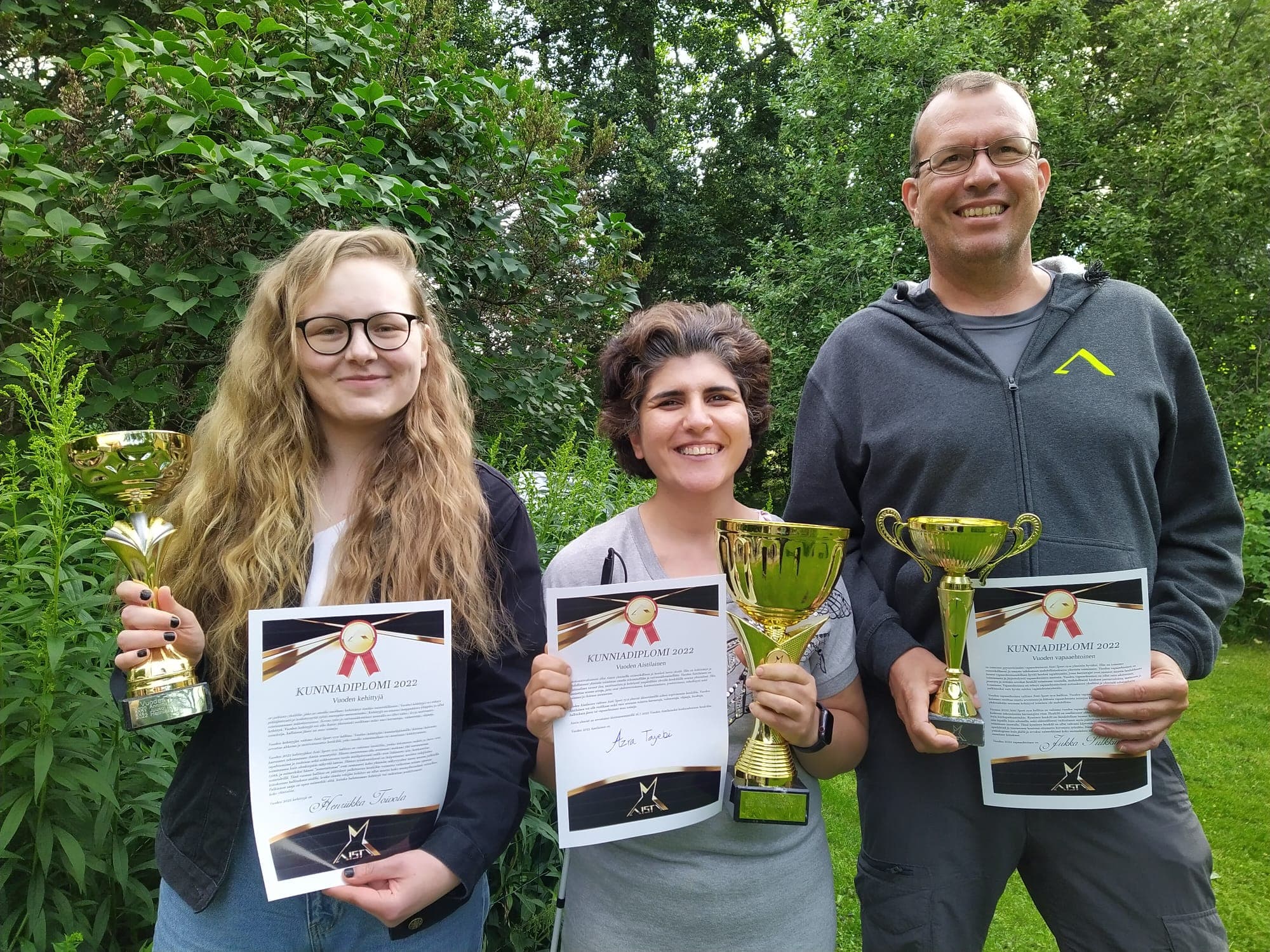Henriikka, Azra ja Jukka yhteiskuvassa pidellen pokaalejaan sekä diplomeitaan.