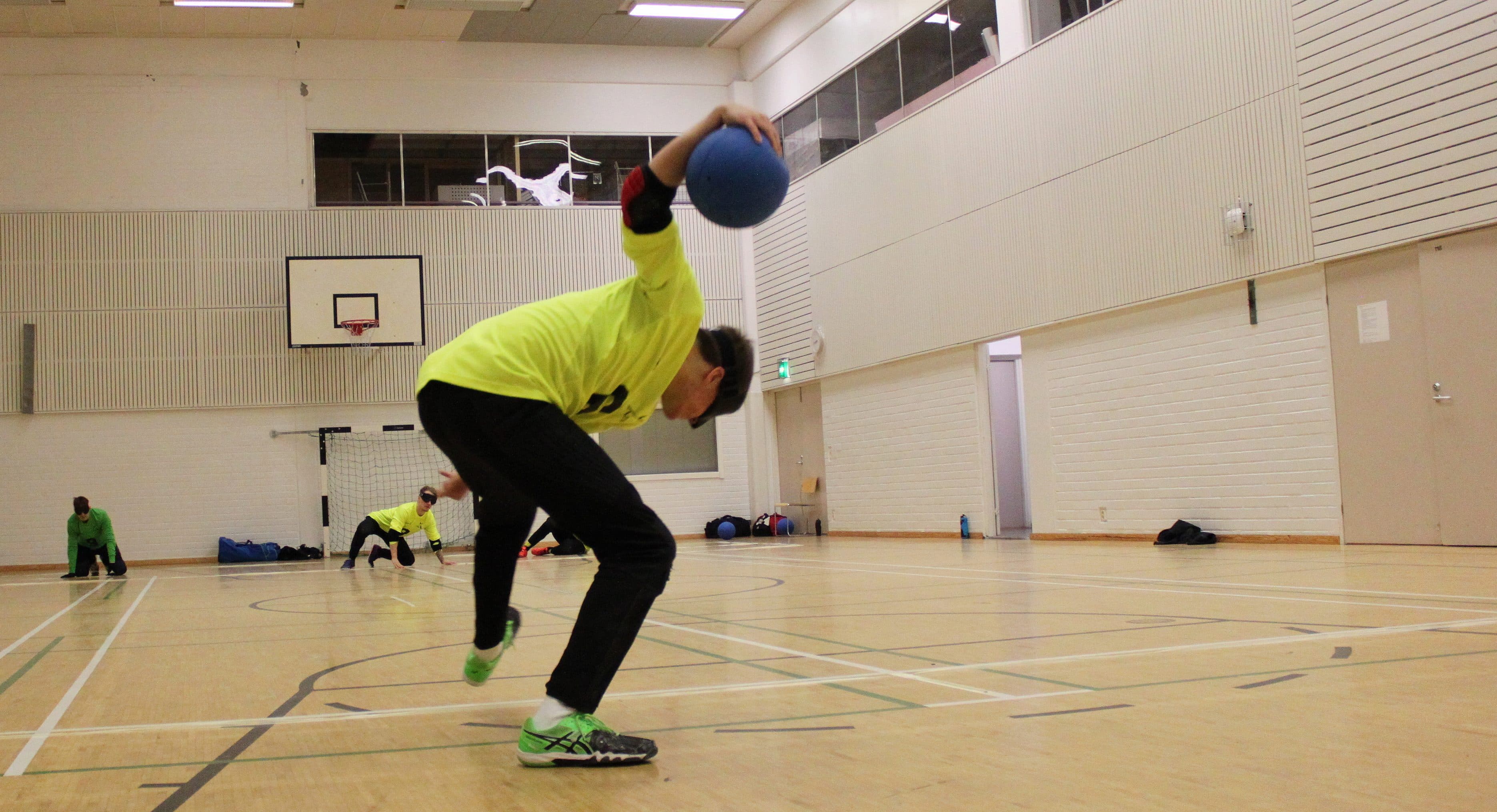 An Aisti Sport player spins into a throw. The opposing Aisti players are ready to block.