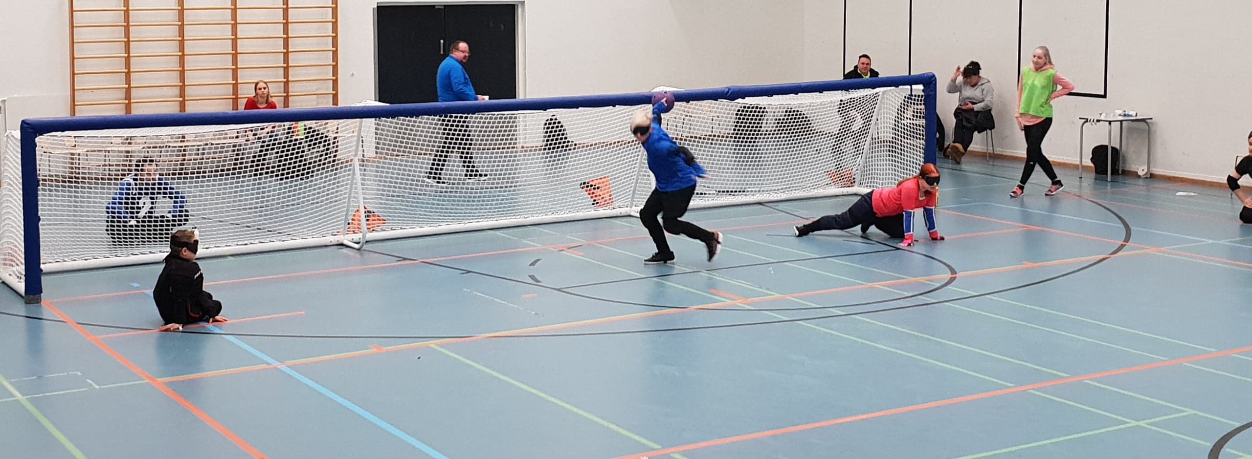 Pelitilannekuva, jossa nuori poika on juuri heittämässä pelitovereiden keskittyessä vierellä.