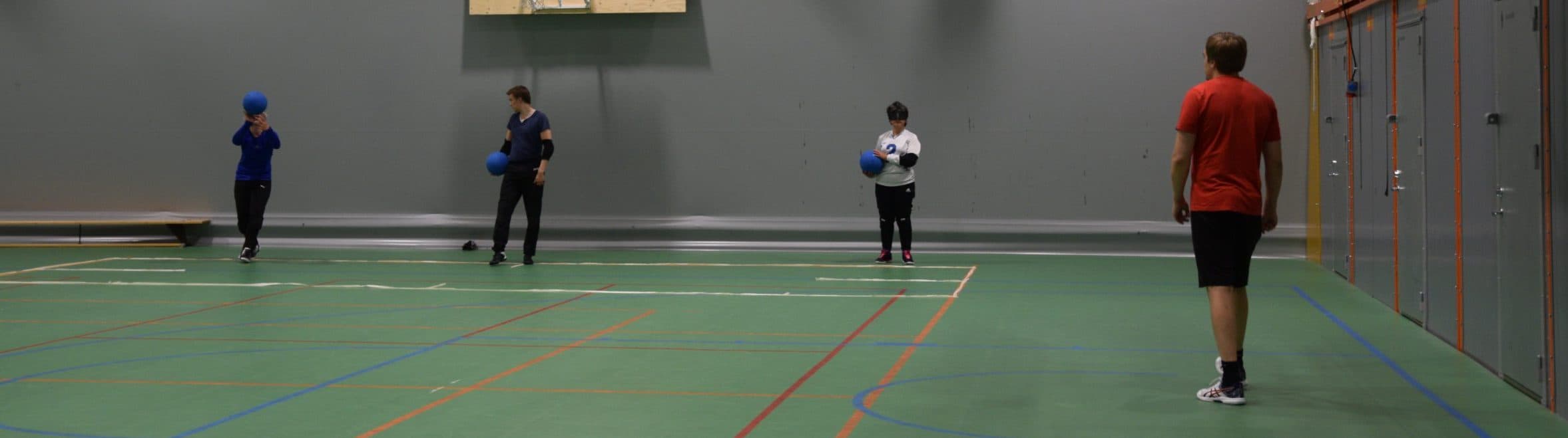 Harjoituskuva jossa pelaajat maaliviivalla rivissä vasemmalta oikealle Eemi, Leo, Azra. Jokaisella pallo kourassa. Kentän laidalla Markus valmentamassa heittäjiä.