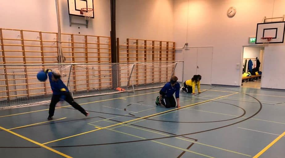 Pelitilannekuva edestäpäin, jossa nuori poika lähtee heittämään palloa vanhempien pelikavereiden valmistautuessa seuraavaan palloon.
