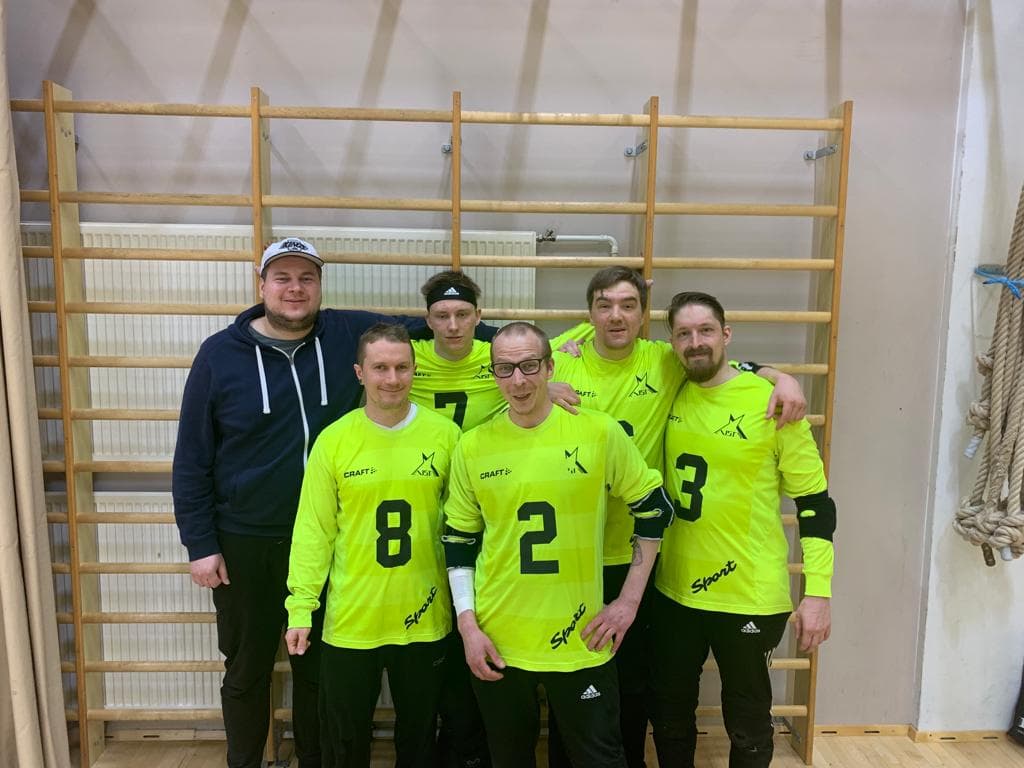 Joukkuekuvassa hymyilevät pelaajat, osalla kädet toistensa olkapäillä, poseeraavat kameralle. Jäsenet vasemmalta oikealle huoltajavalmentaja Petrus Vilhunen, #8 Miika Honkanen, #7 Seemi Hintsanen, #2 Tomi Vesalainen, #6 Markus Tihumäki sekä #3 Samuli Harjunen